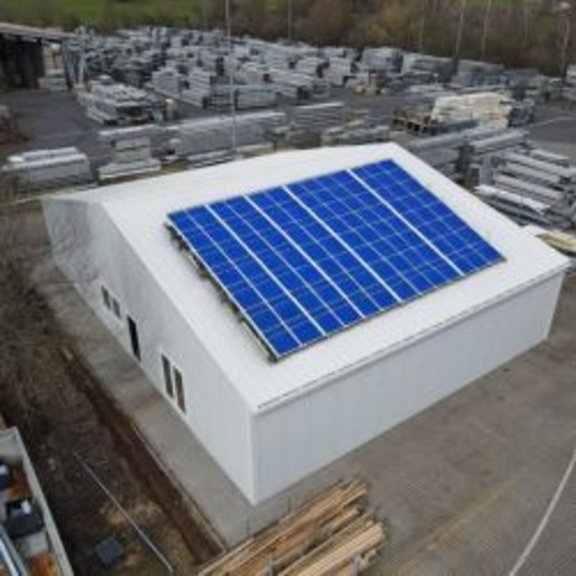 Vogelperspektive auf eine Produktionshalle mit Photovoltaik auf dem festen Dach