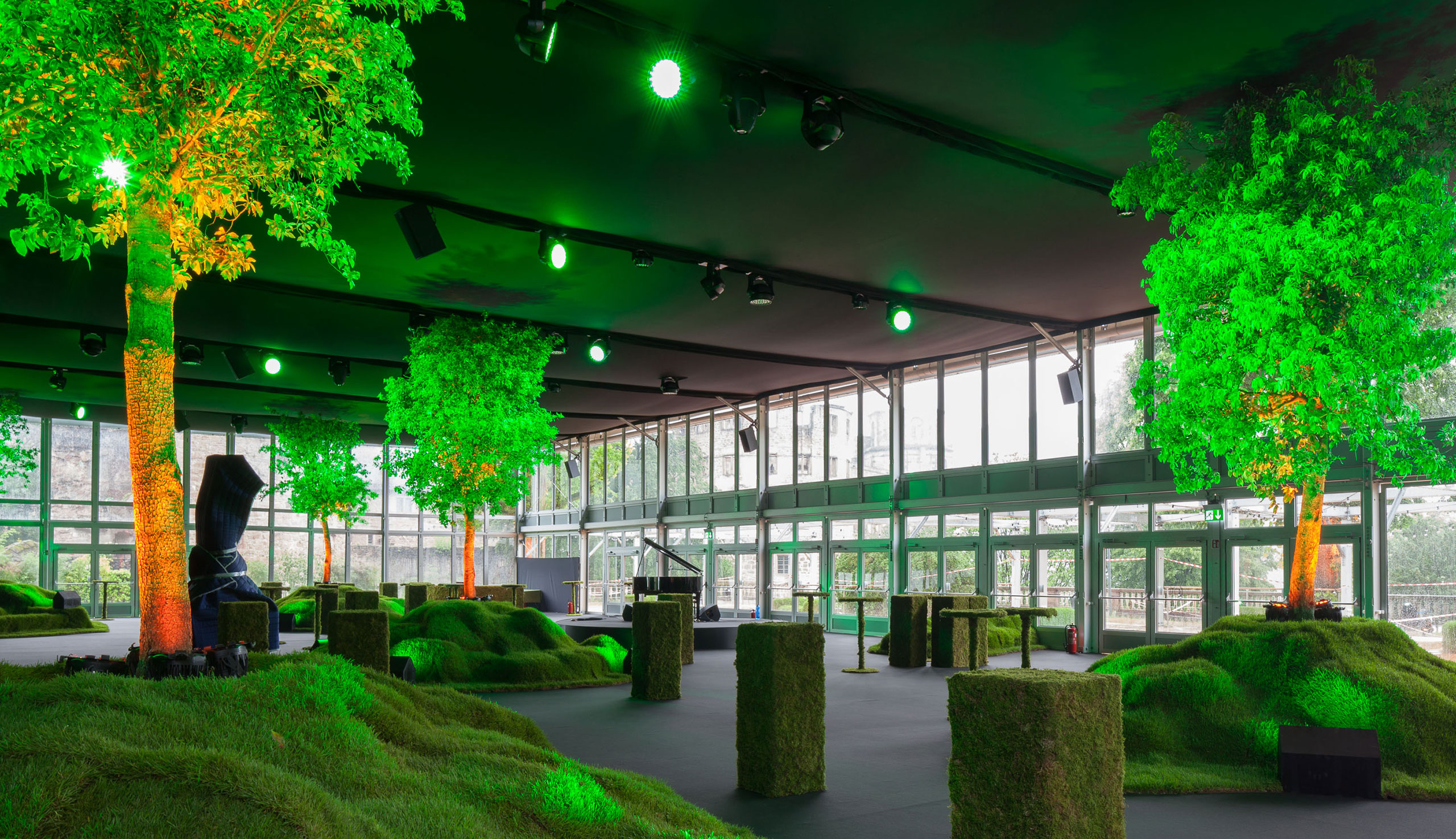 Vue intérieure du showroom avec des arbres éclairés en vert